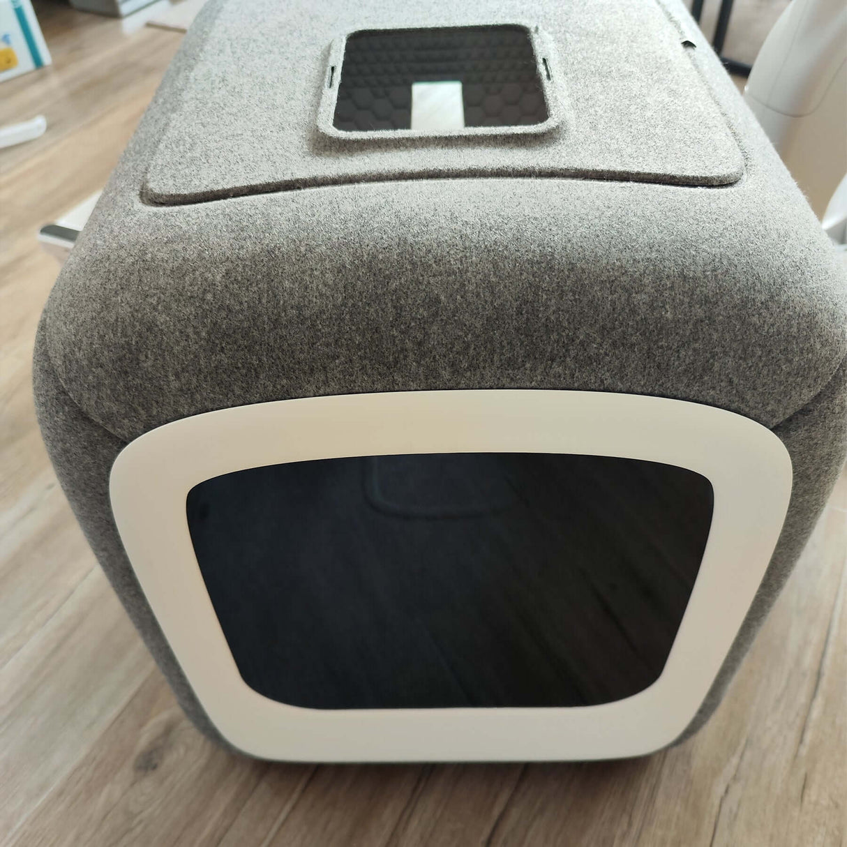 Modern gray pet grooming tool with rounded edges and black entrance opening.