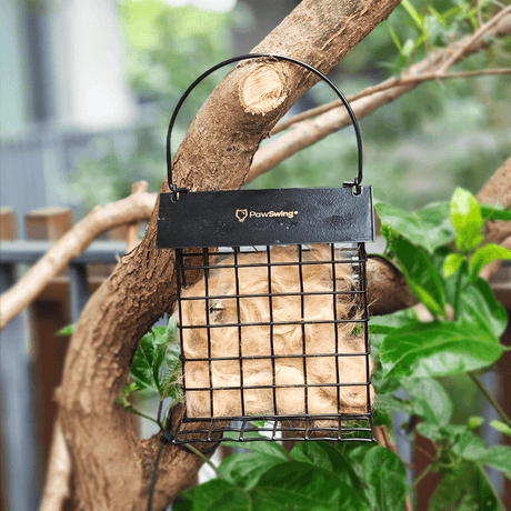 PawSwing Cat Hair Suet Collector hanging on a tree, filled with cat shed fur for birds to use as nesting material.