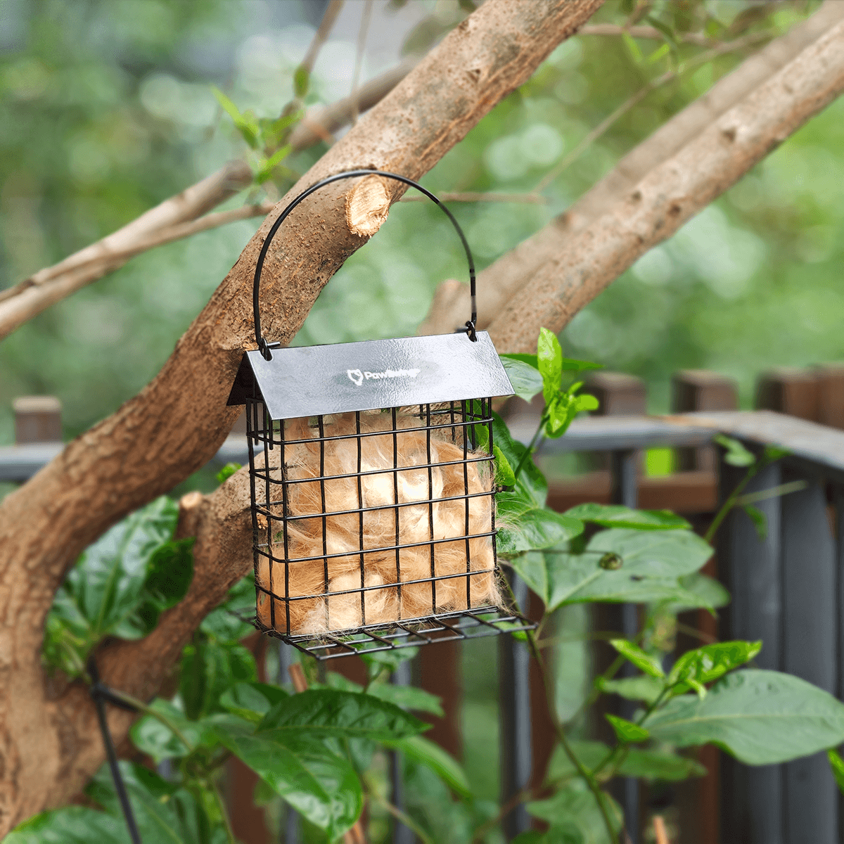 Hanging PawSwing Cat Hair Suet Collector on a tree, filled with cat fur for bird nesting material.
